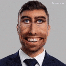 a man in a suit and tie is smiling with a very big smile on his face .
