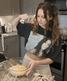 a woman wearing a cher platinum shirt is preparing food