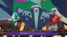 a group of cartoon characters standing next to each other on a stage in front of a colorful background .