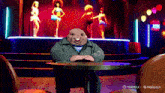 a man sits at a table in front of a sign that says salsa on it
