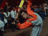 a man in overalls is holding a trophy in his hand