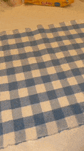 a blue and white checkered table cloth with a package of bubbies on it