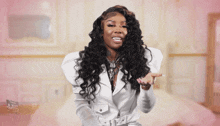 a woman wearing a white jacket with puffed sleeves is pointing
