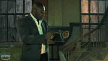 a man is holding a gun in front of a fire and the word prime is on the bottom