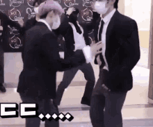 a group of men in suits and face masks are dancing in front of a sign that says fm 106.7