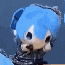 a close up of a doll with blue hair and headphones .