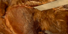a close up of a piece of meat being sliced with a spatula .