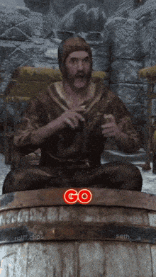 a man is sitting on a wooden barrel with a red go sticker on it
