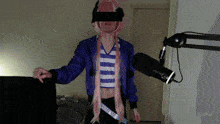 a man in a pink wig is standing in front of a microphone with his eyes covered