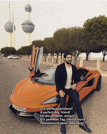 a man sits on the hood of an orange car with a license plate that says 59-57354