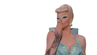 a woman with a tattoo on her arm is wearing a blue dress and earrings