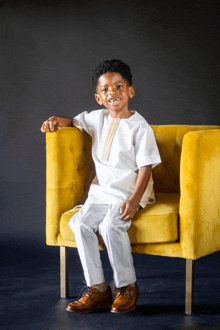 a young boy is sitting in a yellow chair