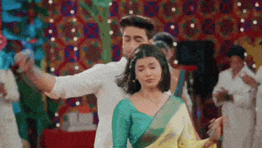 a man and a woman are dancing together in front of a crowd .