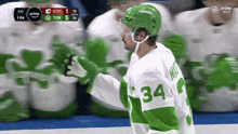 a hockey player wearing a green and white jersey with the number 34