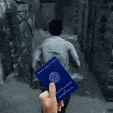 a person is holding a blue passport that says ' secretaria de trabalho e desenvolvimento social ' on it