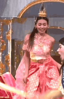 a woman in a pink dress with a gold crown on her head