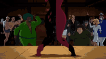 a group of people are dancing in front of a red exit sign