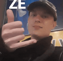 a man giving a thumbs up in front of a sign that says ze on it