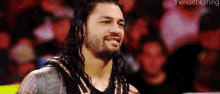 roman reigns is a wrestler with long hair and a beard .