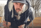 a man with a beard is wearing a black hoodie