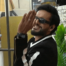 a man with a beard wearing sunglasses is making a funny face