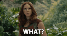 a woman with red hair is standing in a jungle and says what ?