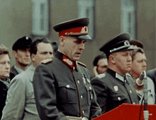a man in a military uniform is standing in front of a podium