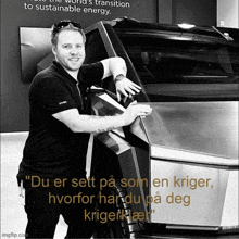 a man standing next to a car with the words " du er sett på som en kriger hvorfor har du på deg kriger "