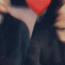 a blurry picture of a man and a woman with a red heart in the background