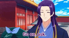 a man with purple hair says go on ask in front of a building