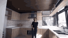 a woman is standing in a kitchen with the words made in animatica on the bottom