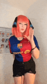 a girl with pink hair is wearing a barcelona shirt and shorts .