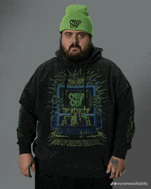 a man wearing a green beanie and a hoodie that says creep cast