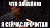 a man holding a book with a meme in russian