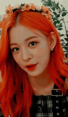 a woman with red hair is wearing a flower crown