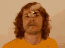 a man wearing a yellow nike shirt is holding a lighter