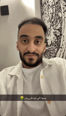 a man with a beard wearing a white shirt and a white jacket