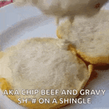 a plate of biscuits with gravy being poured on top of them .