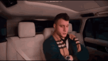 a man is sitting in the back seat of a car with bandcam.com displayed on the bottom of the screen