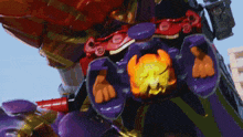 a purple and orange robot with a pumpkin on its chest