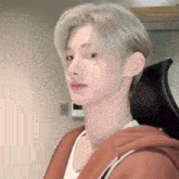 a close up of a person wearing a hoodie and a white shirt .