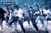 a group of people are dancing in the rain in a room .