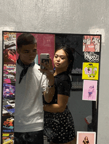 a man and a woman are taking a selfie in front of a mirror with stickers on it including one that says supra