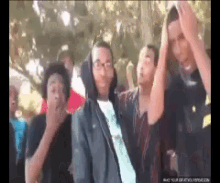 a group of people are standing in a line with their hands up