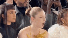 a woman is sitting in the audience at a fashion show .