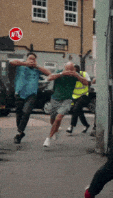 a group of men running down a street with a red sign that says aftv