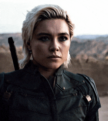 a close up of a woman 's face with a sword in her hand