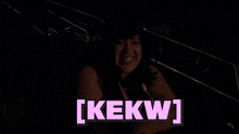 a woman in a dark room with the words [ kekw ] in pink