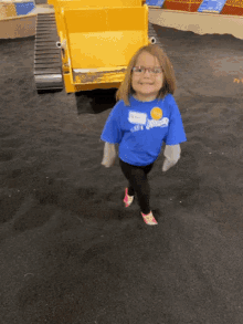a little girl wearing glasses and a blue shirt that says ' jackson '