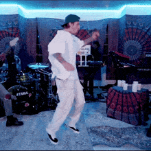 a man is dancing in front of a drum set that says ' tama ' on it